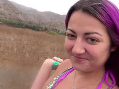 Purple haired Lily Adams gives her boyfriend a blowjob on the beach